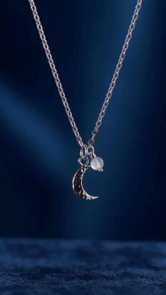 The moon necklace styled, on navy velvet