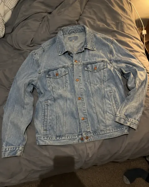 The phone photo: a denim jacket laid on an unmade bed